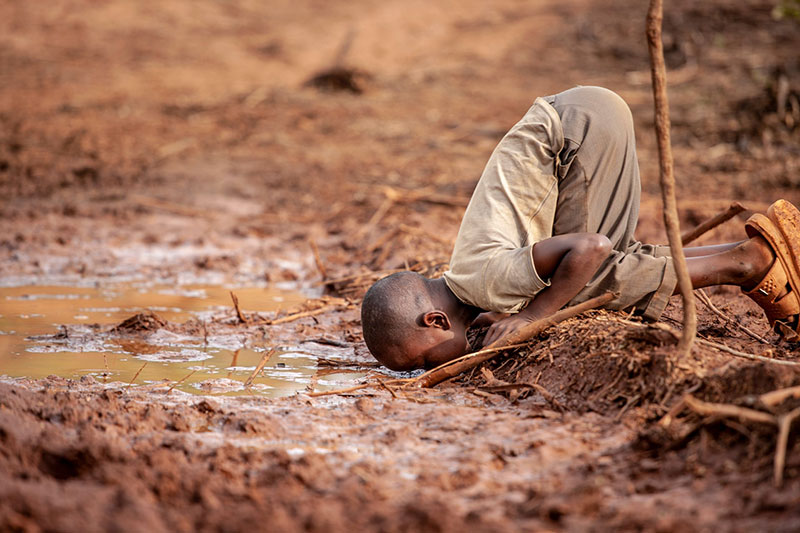 ⬆︎ Un bambino beve acqua sporca a Kakamega, Kenya. Foto di Dharshie Wissah