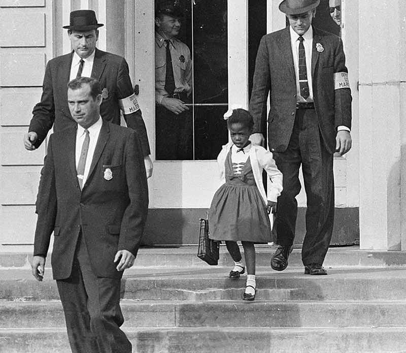 ⬆︎ Ruby Bridges è scortata verso casa da un gruppo di agenti. New Orleans, Usa, 1960. Foto di ??